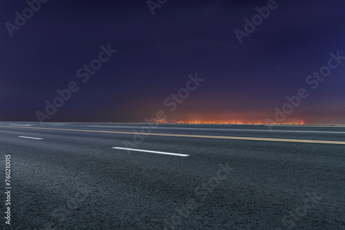 Empty Road Leading to City Lights at Dusk