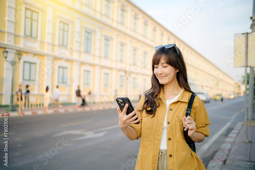 Traveler asian woman in her 30s using smartphone for navigation destination on the urban street at Bangkok, Thailand.