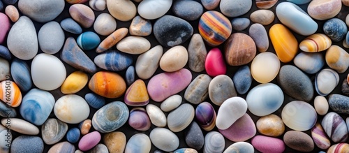 A closeup shot showcasing a vibrant pile of natural rocks in various colors. These stones can be used for building, creating patterns, or even as fashion accessories
