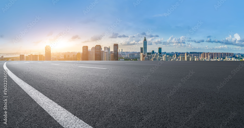 Open Road to Urban Skyline at Sunset