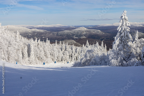 Winter Wonderland. Ski Slopes and Snow-Covered Trees under blue Sky, the Quintessence of Mont Tremblant Landscape. Laurentians, Quebec, Canada