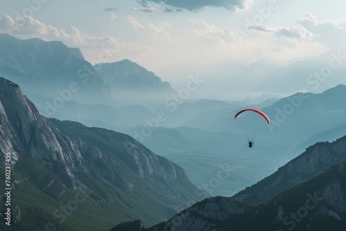 A breathtaking view of a paraglider soaring high above the mountains