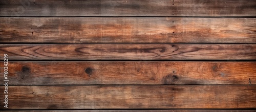 A closeup image showcasing a beautiful hardwood wall with a brown wood stain, creating a captivating pattern of rectangles resembling brickwork, set against a blurred background