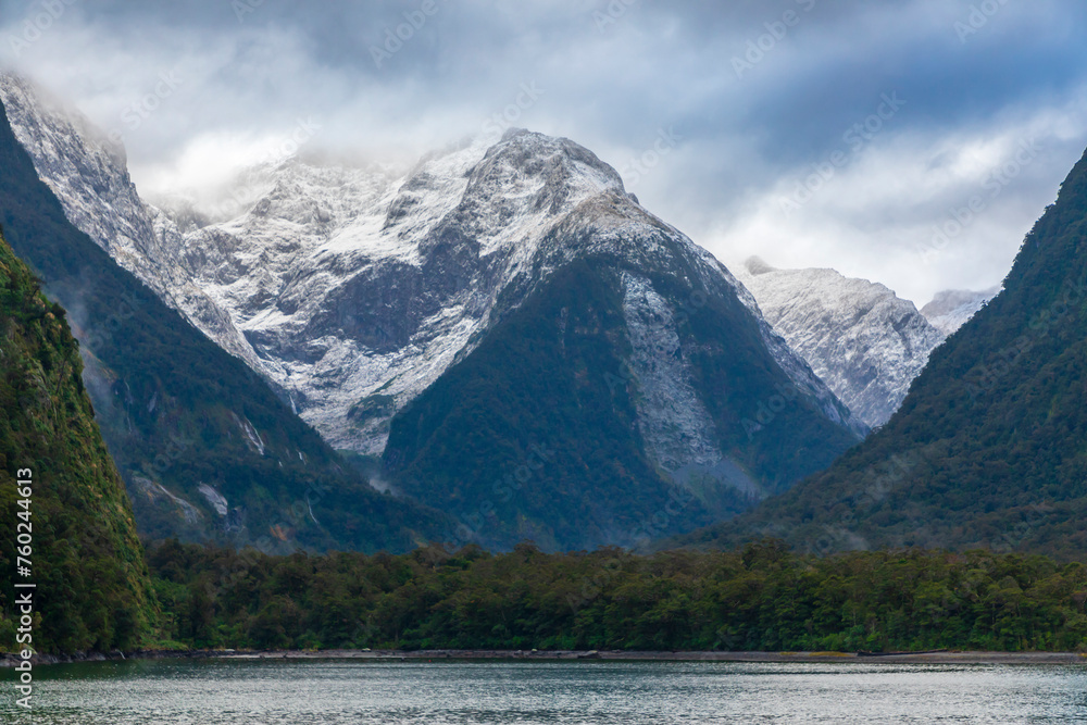 Photograph of mountains in clouds and mist viewed from the water in Milford Sound in Fiordland National Park on the South Island of New Zealand Photograph of mountains in clouds and mist viewed from the water in Milford Sound in Fiordland National Park on the South Island of New Zealand