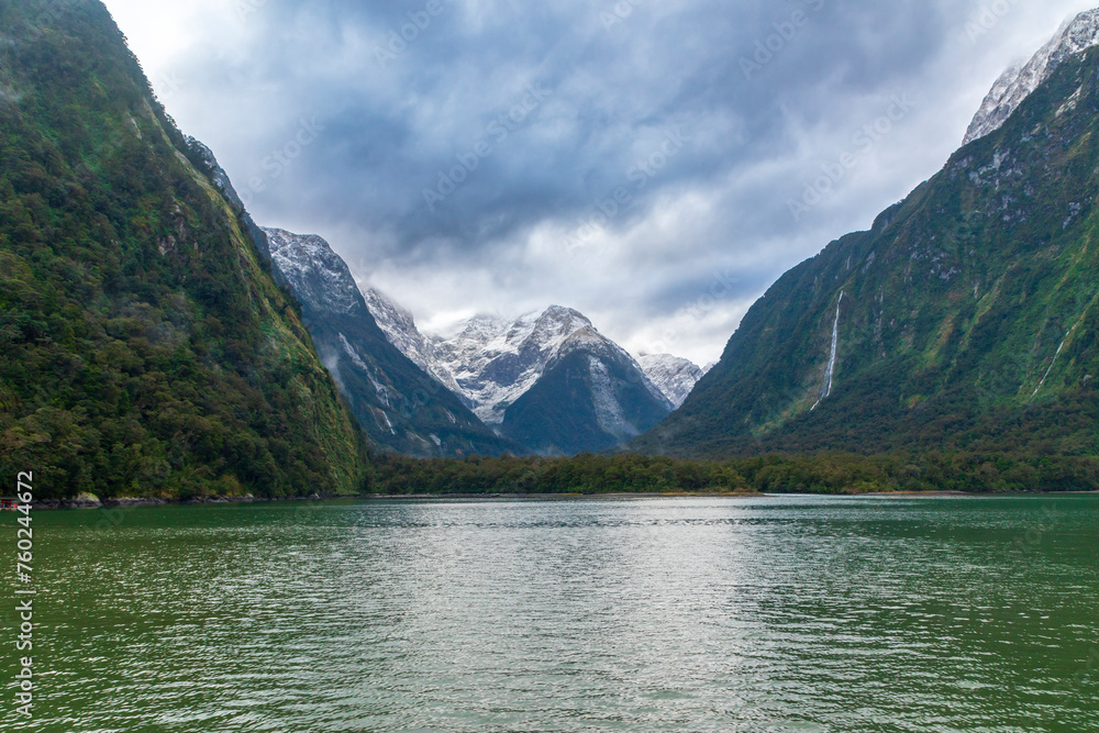 Photograph of mountains in clouds and mist viewed from the water in Milford Sound in Fiordland National Park on the South Island of New Zealand