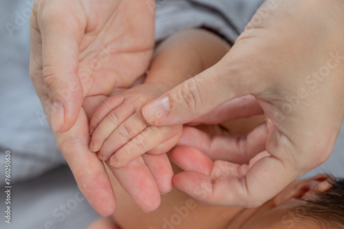 A newborn boy holds his mother s finger. Close-up of hands.
