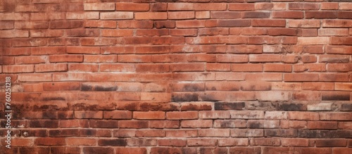 A detailed closeup of a brown brick wall with a peach tint, showcasing the intricate brickwork pattern and rectangular shapes of the building material