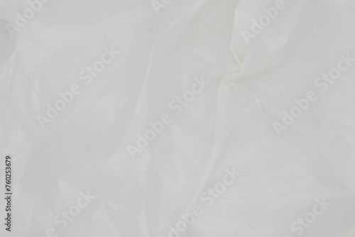 Close up of white plastic bag on white background, The plastic surface is wrinkly and tattered making abstract pattern.