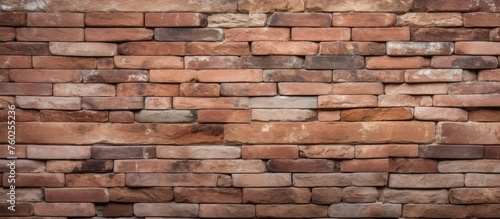 A closeup of a brown brick wall constructed using brickwork, a composite building material made of rectangular bricks