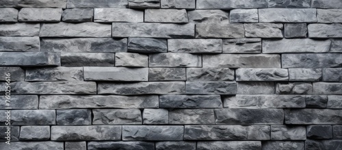 A detailed closeup of a grey brick wall showcasing the intricate brickwork pattern and rectangular stone wall design, highlighting the composite building material used