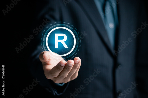 Copyright protection concept. Registration or registration for trademark. Businessman holding Register trademark and logo on virtual screen.