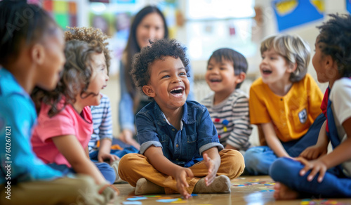 A group of multiethnic children sitting on the floor in an elementary school classroom, laughing and talking to each other
