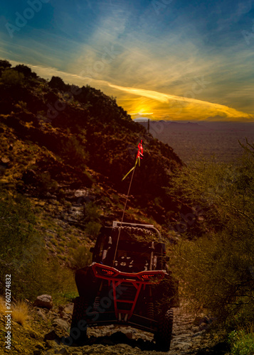 4x4 off road vehicle coming out the mountains at sunset surrounded by the hill side