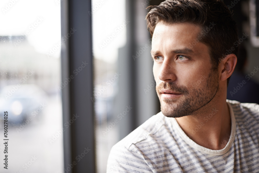 Handsome man, thinking and vision by window at cafe for ambition, travel or sightseeing. Face of male person waiting in wonder or thought at indoor restaurant or coffee shop for break or reflection