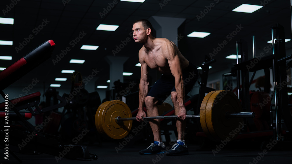 Shirtless man doing bicep exercises with dumbbells in the gym. Shirtless man doing bicep exercises with dumbbells in the gym.