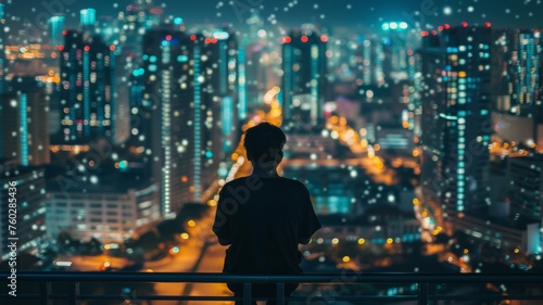 Person overlooking cityscape at night - A contemplative individual stands against a balcony railing, gazing at the brightly lit, bustling cityscape below him at night