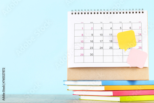 Calendar page with stack of notepads and speech bubbles on blue background