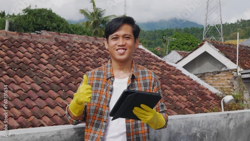 asian construction worker standing hold tablet with smiling, giving thumb up looking at the camera