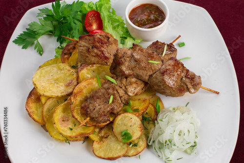 Delicious kebab with fried potatoes on a plate, menu for a restaurant
