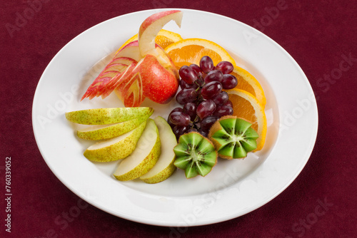 A plate of tropical fruits standing on red velvet