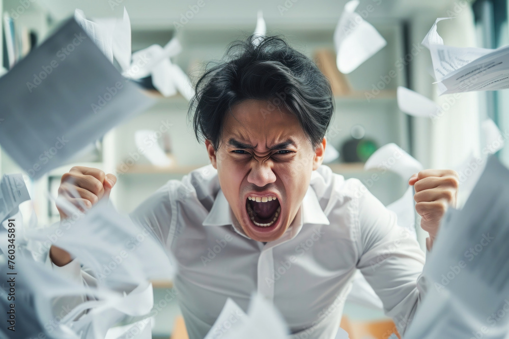Obraz premium Pissed off asian office worker cluttered with paperwork shouting, theme or concept of a rush at work