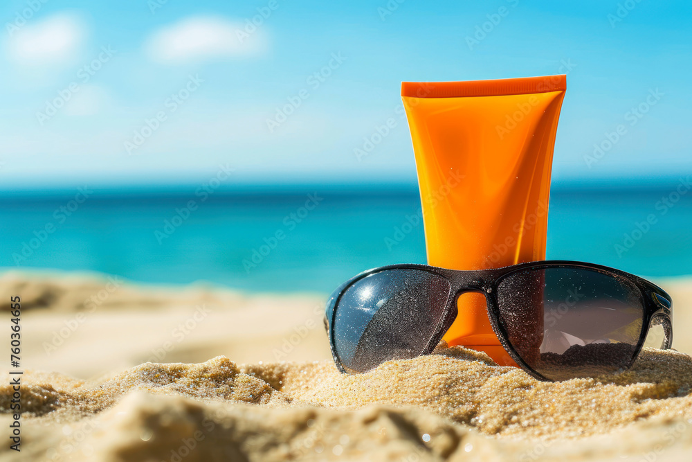 Sunscreen lotion, sunglasses on sandy beach as background