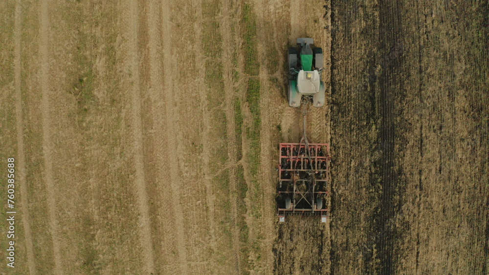 The tractor is working in the field. The tractor pulls the seeding unit, top view. The tractor is working in the field. The tractor pulls the seeding unit, top view.