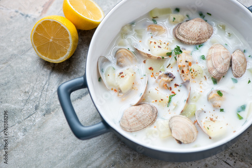 New England chowder with vongole clams in a serving pan, middle close-up, horizontal shot on a grey granite surface