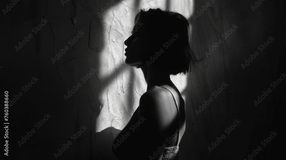 Silhouette of a young woman in a dark room with shadows Silhouette of a young woman in a dark room with shadows