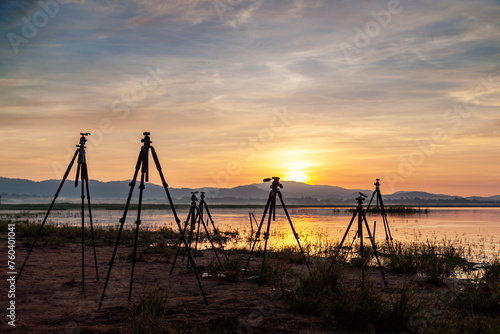 View of group of tripod and the lake background at sunrise sky. Landscape photography.