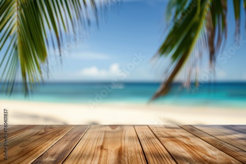 Wooden table with blurred bokeh light seascape and palm leaves at tropical beach background