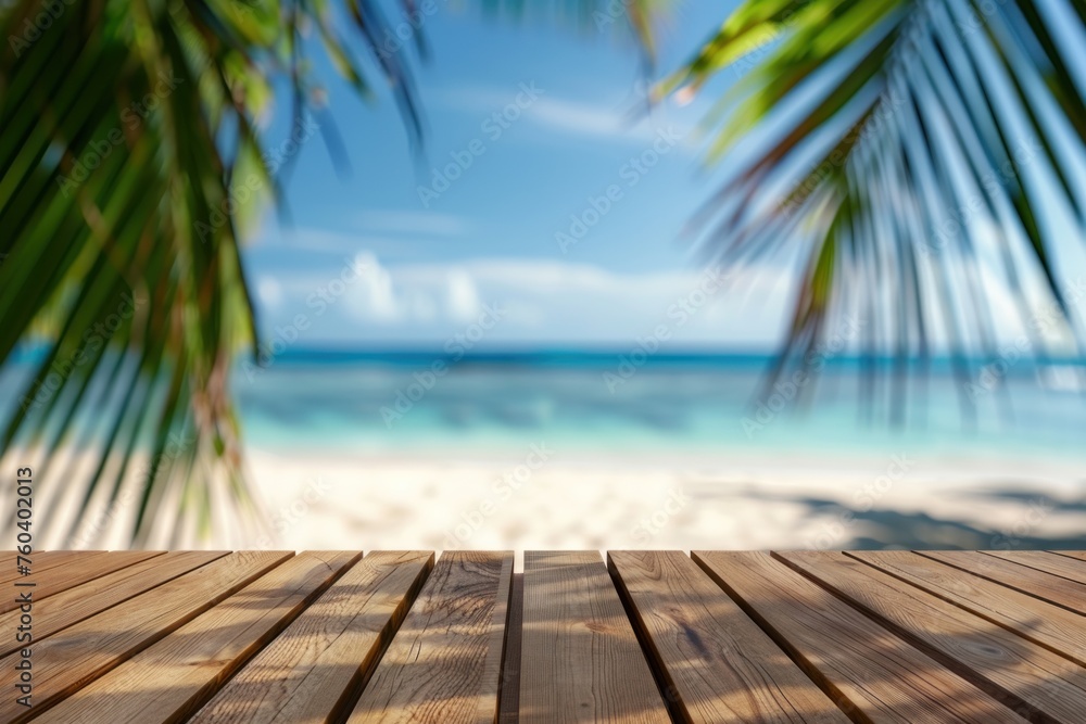 Wooden table with blurred bokeh light seascape and palm leaves at tropical beach background