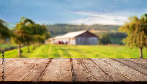 The empty wooden brown table top with blur background of farm and barn. Exuberant image. for text to present products