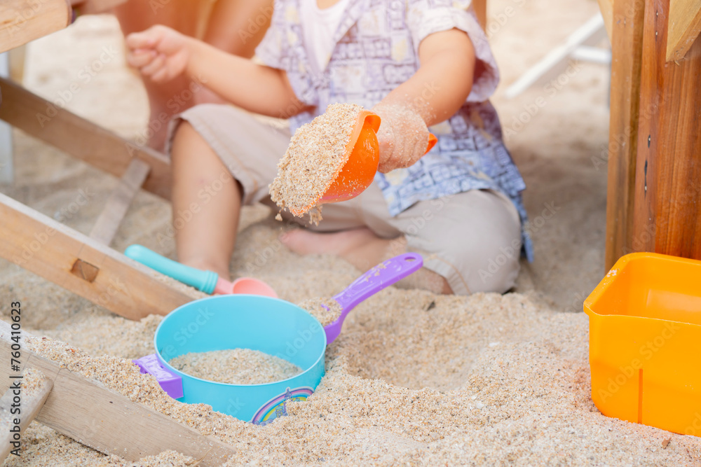 Cropped image of child boy have fun digging in the sand at the beach. Cropped image of child boy have fun digging in the sand at the beach.