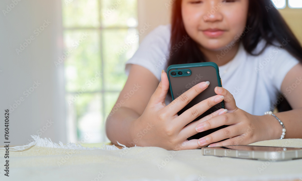 Cropped image of young pretty girl sitting at a table at cafe and using her smartphone. Cropped image of young pretty girl sitting at a table at cafe and using her smartphone.
