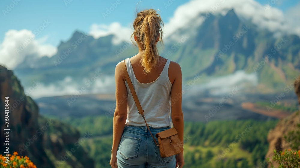 Young woman traveler with backpack on background of mountains and blue sky.
