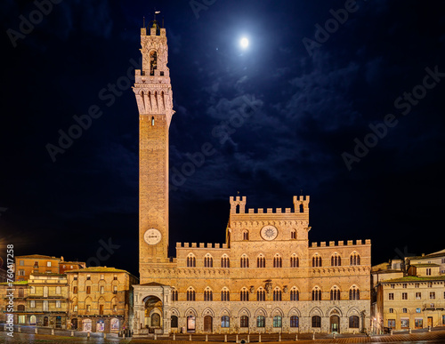Siena, Tuscany, Italy: night view of the ancient town hall Palazzo Pubblico and the tower Torre del Mangia in the city square Piazza del Campo