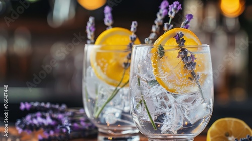 Refreshing gin tonic drinks with lavender and orange slice garnishes, surrounded by warm bokeh lights, suggesting a festive atmosphere.