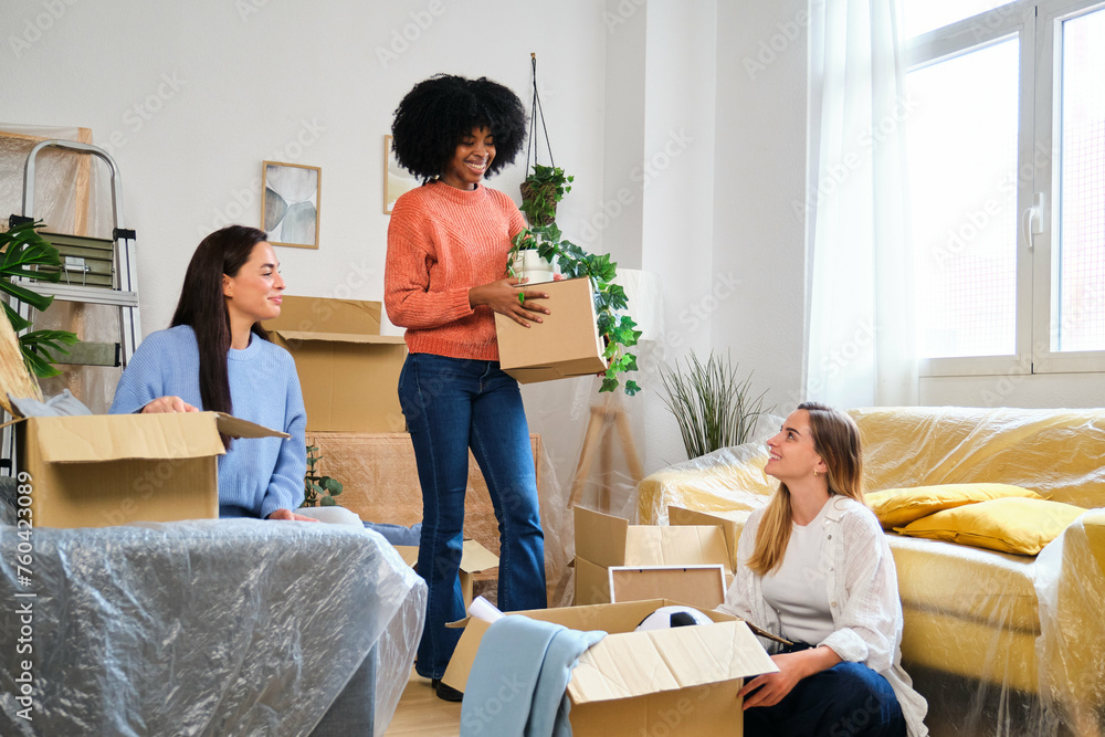 Group of three female friends moving into student flat. New residence relocation.