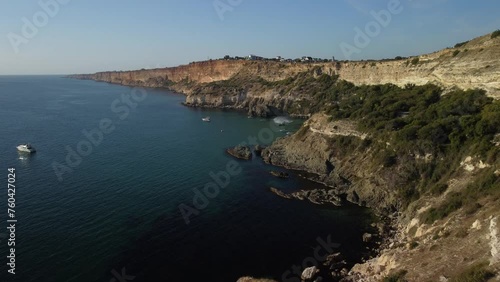 A man flies on a FlyBoard. Aerial top down view. Water extreme sport, azure summer sea with outdoors active people enjoying water sports. Flyboarding and seariding, Recreation and sports concepts. photo