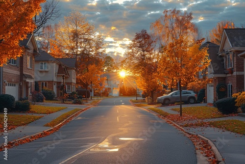 Tranquil residential road with homes and autumnal foliage during sundown.