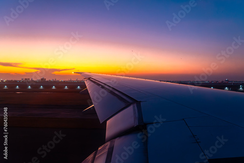 Beautiful sunset  sky on the top view  airplane flying view from inside window aircraft of Traveling. View of the clouds and airplane wing from the Inside. 
