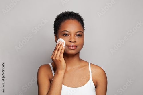 Attractive healthy woman with fresh skin holding white cotton pad in her hand. Medicine, treatment and skin cleansing concept