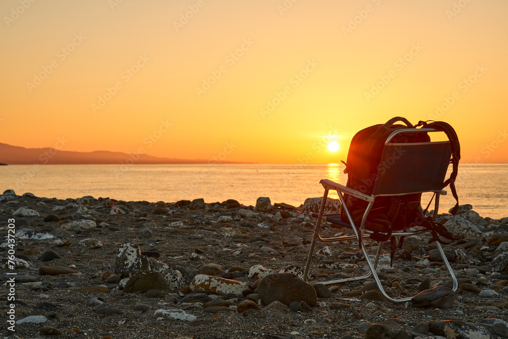 amanecer en la playa con una silla y una mochila amanecer en la playa con una silla y una mochila