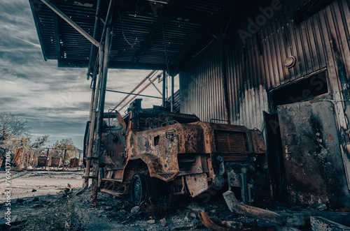 burnt military armored car on the street of the ruined city
