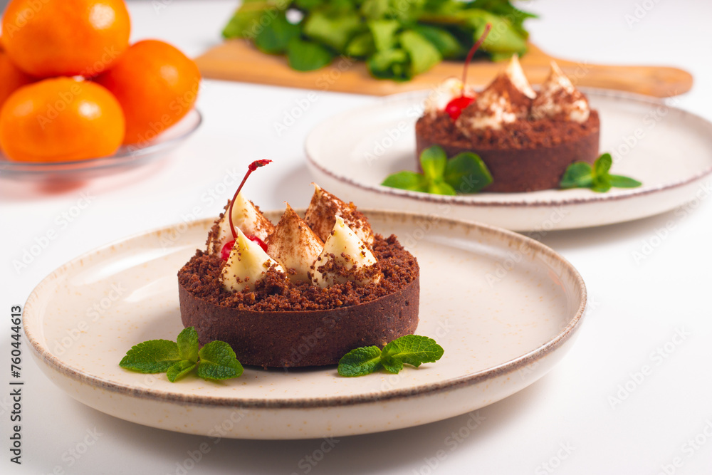Delicious chocolate tart garnish with cherry and mint. Classic dessert. Delicious chocolate tart garnish with cherry and mint. Classic dessert.