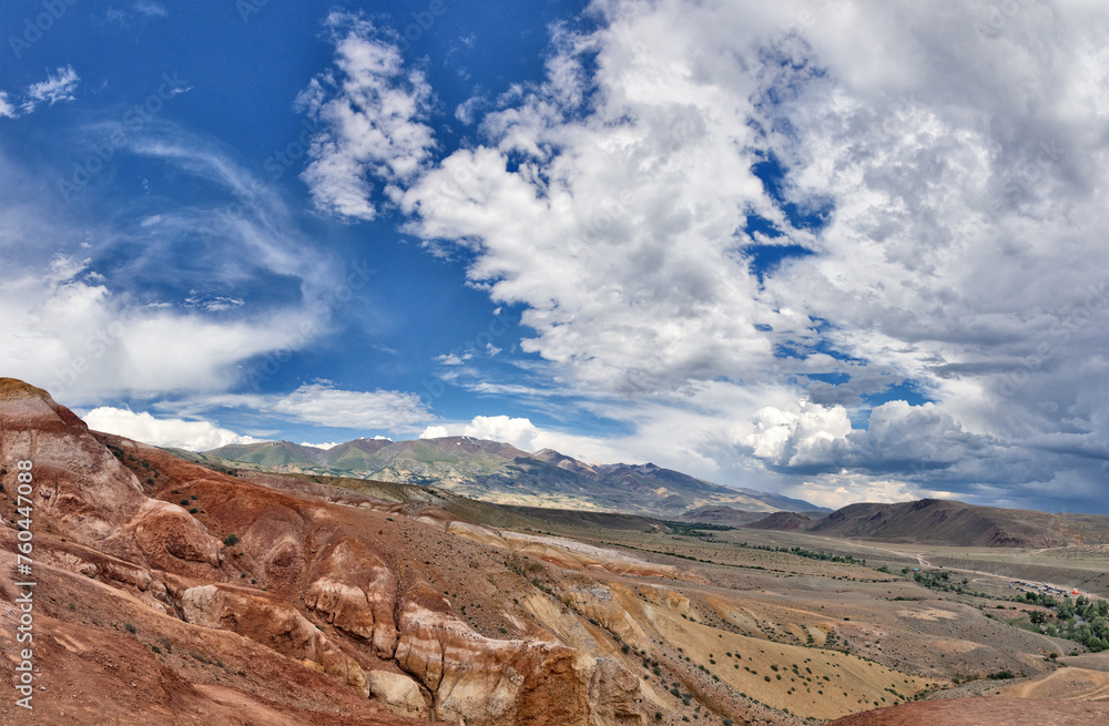 brown and red mountains under fine large clouds