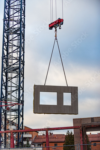 Prefabricated Wall Panels hanging from a crane being install in a building.