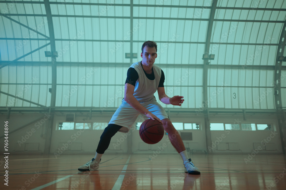 Professional basketball player training in an empty basketball stadium.