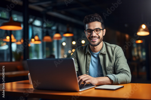 A man is sitting at a table with a laptop in front of him
